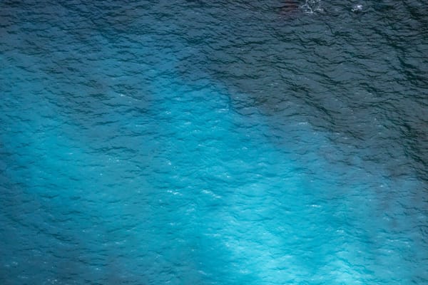 Sunlight filtering through rippled ocean water, creating shifting shades of blue.