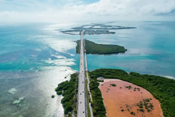 Aerial view of a coastal highway crossing low-lying islands and shallow turquoise waters.