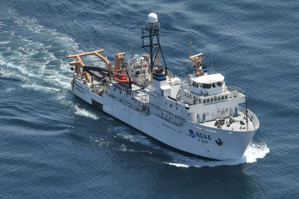 NOAA oceanographic research vessel underway at sea, viewed from above with scientific equipment visible on deck.
